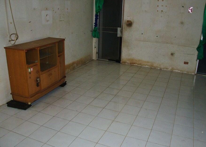 Habitación antigua con un aparador de madera como único mueble pendiente de retirar — Piso heredado de 95 m² en Benalúa, Alicante
