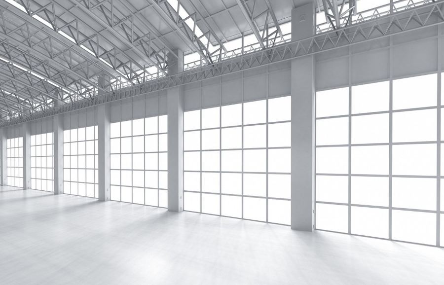 Nave industrial luminosa y vacía con grandes cristaleras — Vaciados Alicante: vaciamos pisos, casas y locales en 24–48 horas